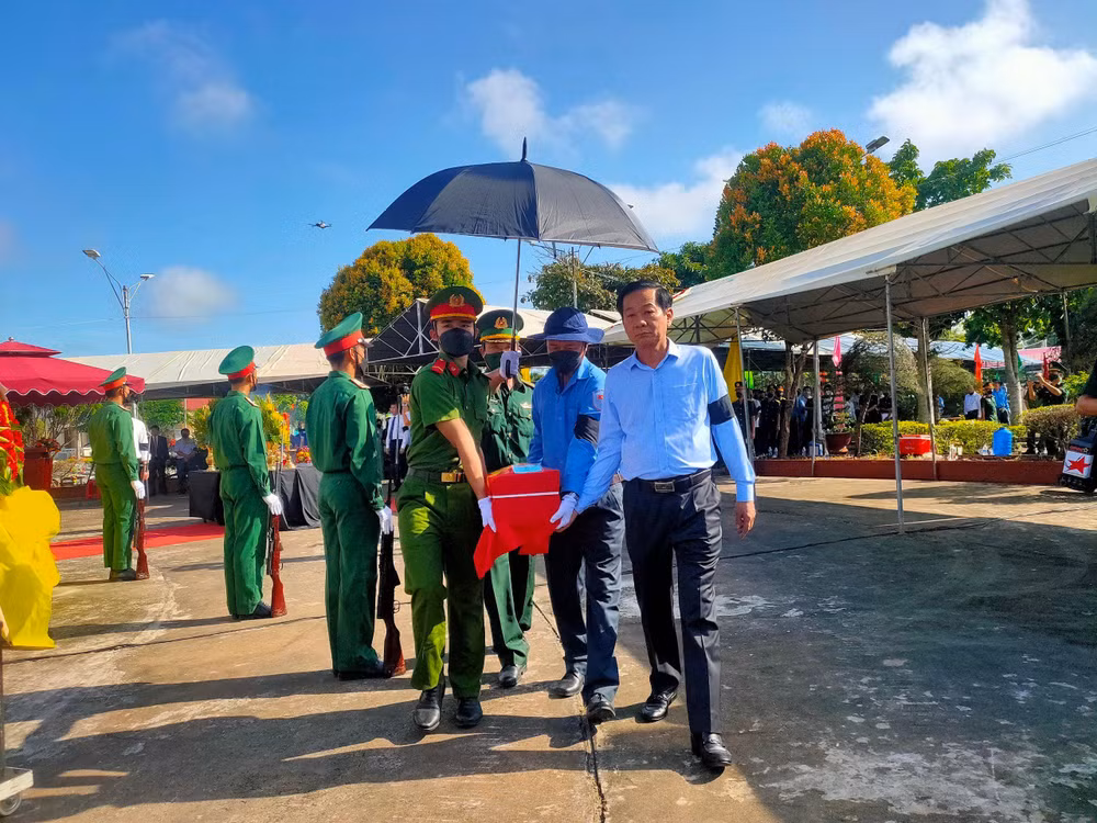 Đồng chí Đỗ Thanh Bình (phải) thực hiện nghi thức an táng hài cốt liệt sĩ hy sinh tại Vương quốc Campuchia, tại Nghĩa trang Liệt sĩ huyện Hòn Đất, tỉnh Kiên Giang, ngày 25/7. 