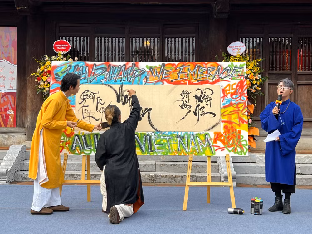 Các nghệ sĩ graffiti và các nhà thư pháp bên tác phẩm chung được trình diễn ngay tại lễ khai mạc.