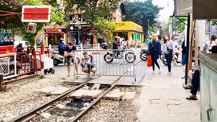 Khách nước ngoài chụp ảnh đường tàu ở khu vực ngoài rào chắn.