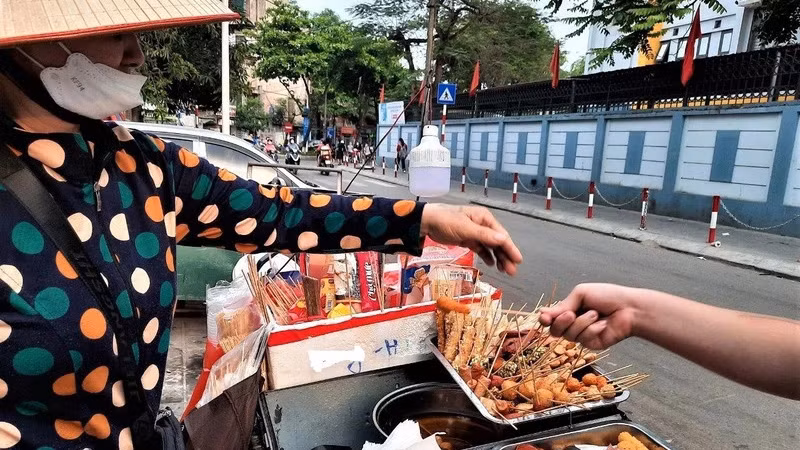 Những quán hàng rong với nhiều loại thức ăn, nước uống được bày bán tại khu vực cổng trường học có nguy cơ không bảo đảm vệ sinh an toàn thực phẩm. (Ảnh ĐỖ VI)