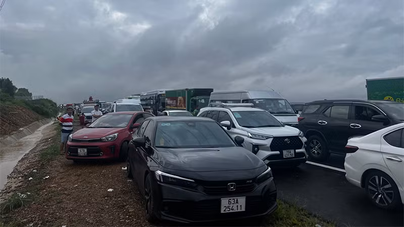 Nước ngập cao, chỉ những xe ô-tô gầm cao mới di chuyển chậm qua khu vực bị ngập, còn lại những xe gầm thấp đều bị kẹt lại không thể đi qua.