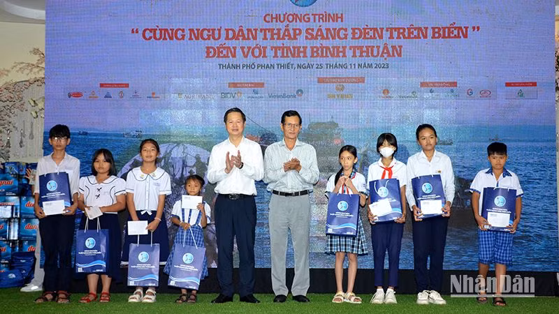 Đại diện lãnh đạo Ủy ban nhân dân tỉnh Bình Thuận trao tặng quà cho học sinh là con em ngư dân vượt khó học giỏi.