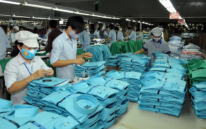 Công nhân may quần áo xuất khẩu tại Xí nghiệp may Hà Quảng, tỉnh Quảng Bình. (Ảnh NGUYỄN ÐĂNG) 