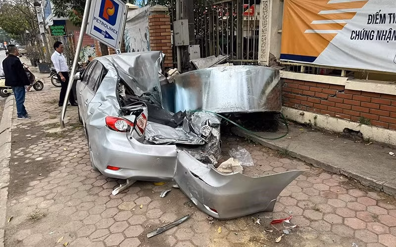 Cuộn thép rơi từ xe chuyên chở trên tỉnh lộ 419 (huyện Thạch Thất, Hà Nội) khiến một ô-tô đang đỗ trên vỉa hè biến dạng hoàn toàn. (Ảnh Minh Hạnh) 