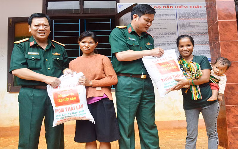 Cán bộ Công ty 75 (Binh đoàn 15) đến thăm, hỗ trợ gạo cho bà con dân tộc thiểu số địa phương trên địa bàn đóng quân. 