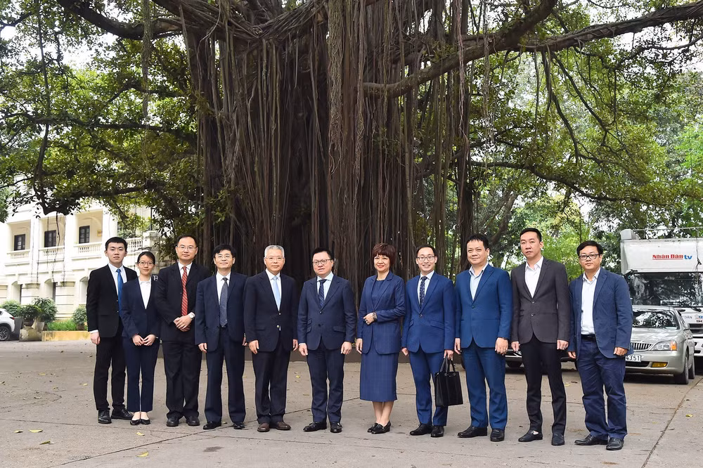 Lãnh đạo Báo Nhân Dân, đại diện Ban Đối ngoại Trung ương và Đoàn đại biểu Ban Liên lạc Đối ngoại Trung ương Đảng Cộng sản Trung Quốc chụp ảnh lưu niệm dưới Gốc đa 71 Hàng Trống. (Ảnh: THỦY NGUYÊN)