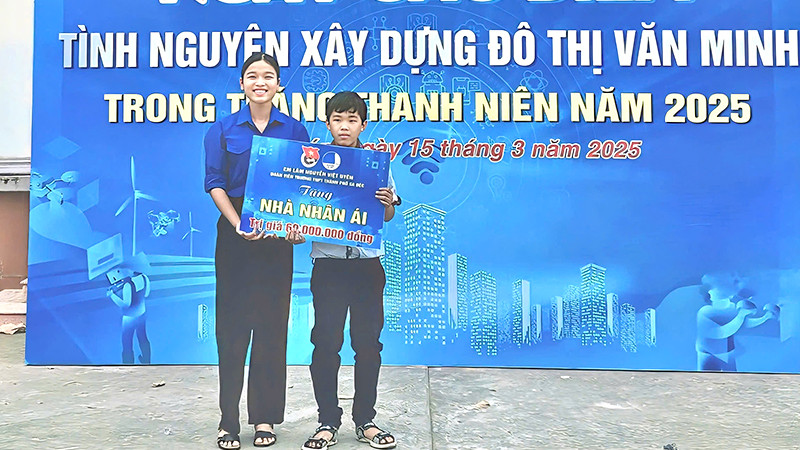 Em Lâm Nguyễn Việt Uyên trao bảng tượng trưng cho em Lý Thiện Đức. (Ảnh: TRUNG THÀNH)