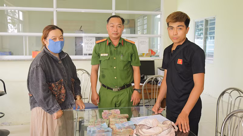 Anh Nguyễn Thanh Duy nhận lại số tiền để quên. (Ảnh: Công an Đồng Tháp)
