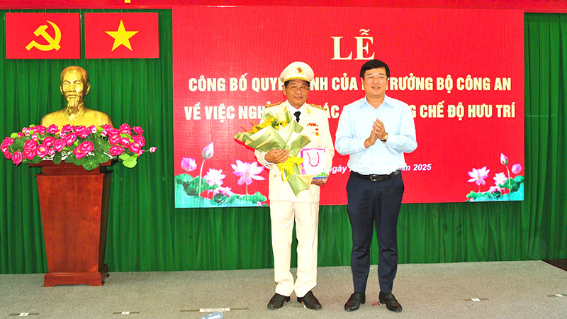 Ủy viên Trung ương Đảng, Bí thư Tỉnh ủy Đồng Tháp Lê Quốc Phong trao Huy hiệu 40 năm tuổi Đảng và tặng hoa chúc mừng Đại tá Nguyễn Văn Hiểu. (Ảnh: Công an cung cấp)