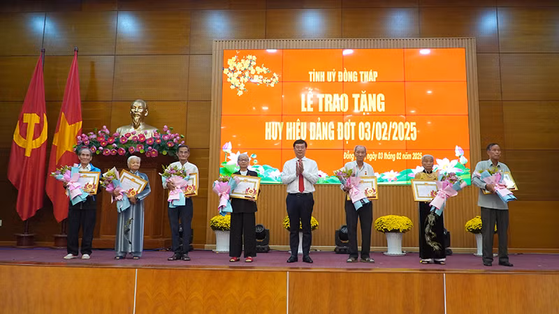 Bí thư Tỉnh ủy Đồng Tháp Lê Quốc Phong trao tặng Huy hiệu 65 năm và 60 năm tuổi Đảng cho 7 đồng chí. (Ảnh: HỮU NGHĨA)