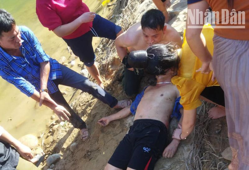 Đại úy Quàng Văn Tám và người dân sơ cứu ban đầu cho anh Giàng A Dệnh.