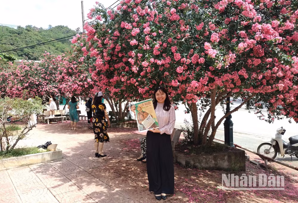 Một bạn đọc lưu giữ khoảnh khắc đẹp bên hoa Tường Vi cùng ấn phẩm Nhân Dân Cuối tuần số 1890 kỷ niệm 135 năm Ngày sinh Chủ tịch Hồ Chí Minh - một con số đặc biệt ý nghĩa, mang tên “Lời Người-Lời của nước non”.
