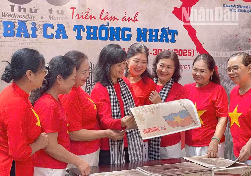 Khách tham quan triển lãm ảnh “Bài ca thống nhất” chào mừng kỷ niệm 50 năm Ngày Giải phóng miền nam, thống nhất đất nước cùng phụ san đặc biệt của Báo Nhân Dân tại Bảo tàng và Thư viện tỉnh Sơn La.