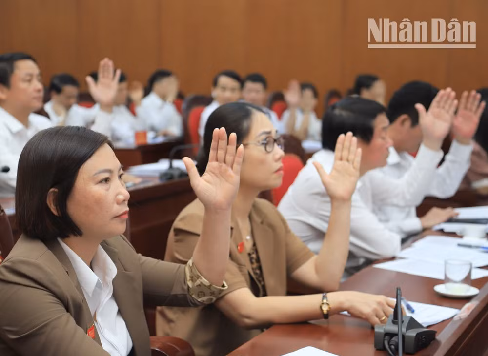 Các đại biểu Hội đồng nhân dân tỉnh Sơn La biểu quyết thông qua nghị quyết kỳ họp.