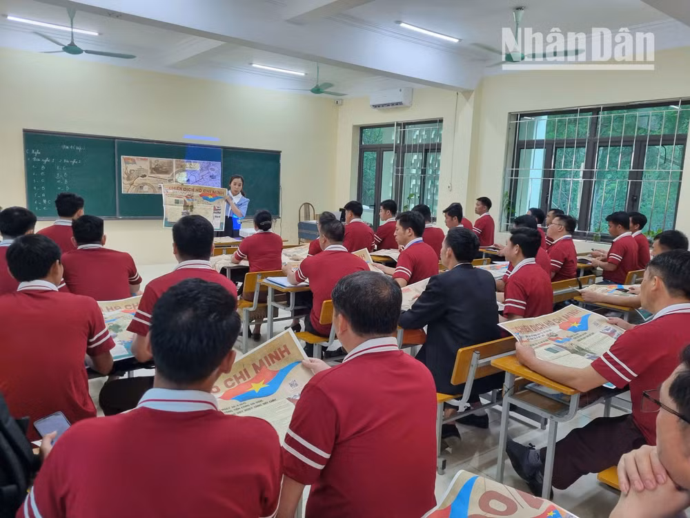 Giáo viên Trường cao đẳng Sơn La còn giới thiệu cho cán bộ Lào đang học tập tại trường về phụ san đặc biệt của Báo Nhân Dân.