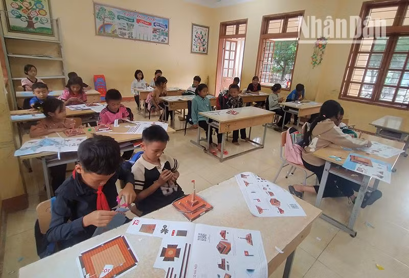 Các em học sinh dân tộc H'Mông và Thái tại tiểu học Co Mạ 2, huyện Thuận Châu đang hoàn thiện mô hình Cột cờ Hà Nội.