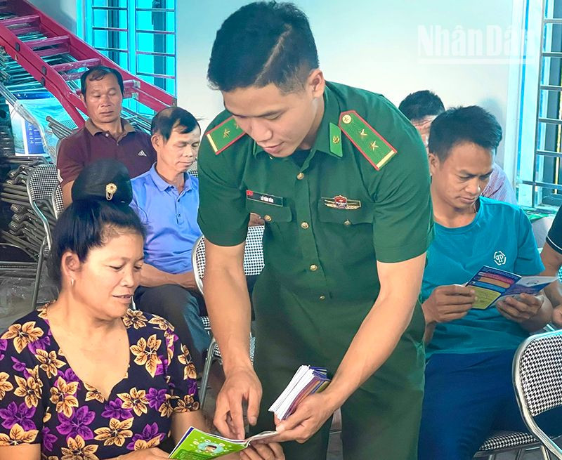 Cán bộ Đồn biên phòng Mường Lạn phát tờ gấp tuyên truyền pháp luật cho bà con dân tộc thiểu số tại xã biên giới Nậm Lạnh, huyện Sốp Cộp.