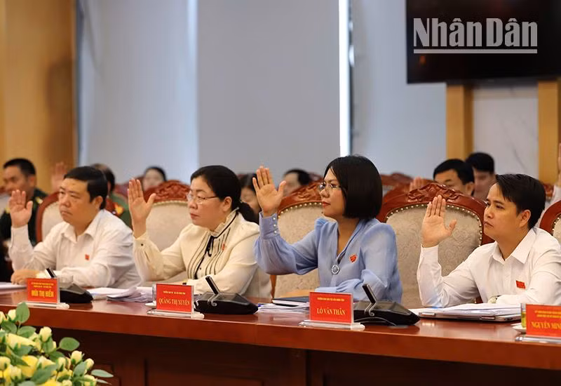 Các đại biểu Hội đồng nhân dân tỉnh Sơn La biểu quyết thông qua các nghị quyết được trình tại kỳ họp.