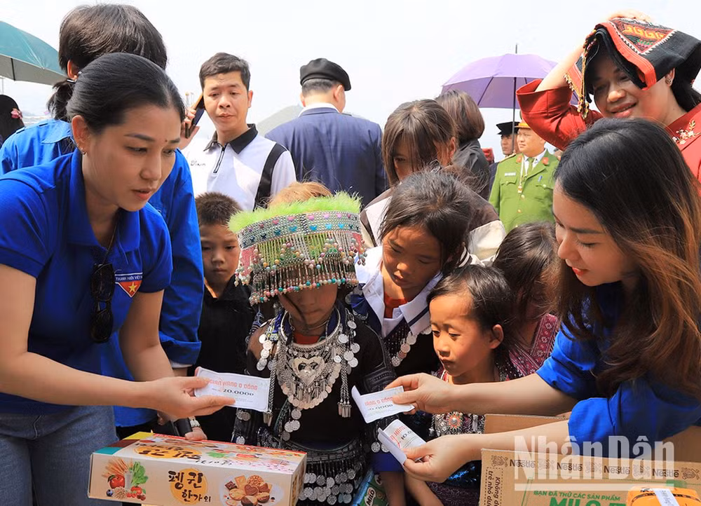 Đoàn viên thanh niên phát phiếu mua hàng cho học sinh có hoàn cảnh khó khăn xã Ngọc Chiến.