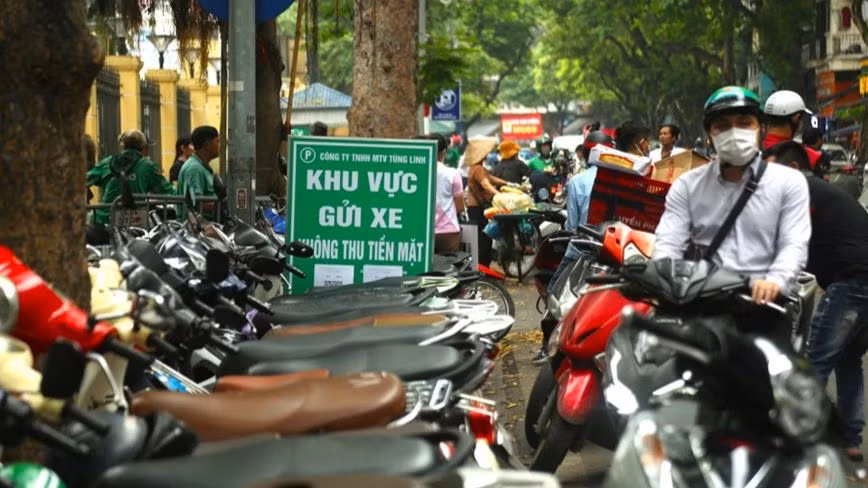 Điểm trông giữ xe máy hạn chế dùng tiền mặt trên phố Phủ Doãn.