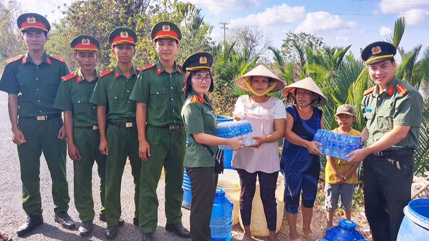 Công an Sóc Trăng tặng nước uống đóng chai cho người dân.