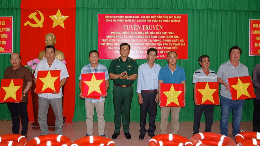 Tặng cờ Tổ quốc và phao cứu sinh cho ngư dân.
