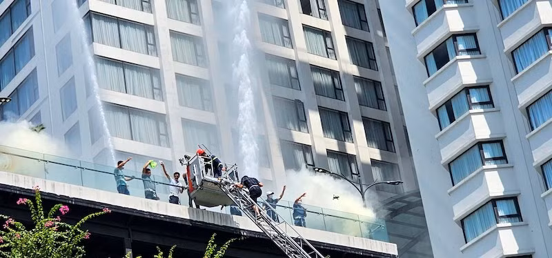 Lực lượng chức năng dùng xe thang cao 32 mét đưa người ra khỏi khách sạn an toàn.