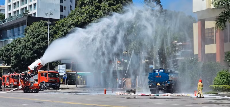 Lực lượng chức năng triển khai dập tắt vụ cháy nổ do xe chở xăng đâm vào xe chở hóa chất.