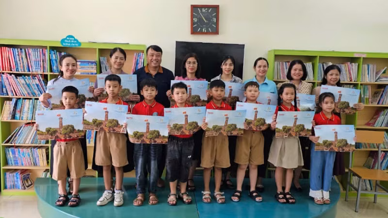 Đại diện Văn phòng Báo Nhân Dân tại Quảng Ninh tặng ấn phẩm đặc biệt "Cột cờ Hà Nội" cho Trường tiểu học thị trấn Đầm Hà, Quảng Ninh.