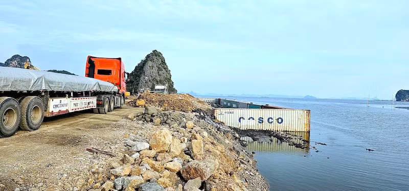 Đơn vị thi công sử dụng container làm kè chắn hạn chế đất đá trôi ra biển trong quá trình thi công. 