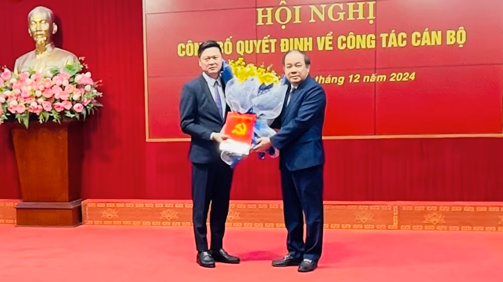 Đồng chí Tạ Văn Long trao quyết định cho Phó Bí thư Huyện ủy Trần Việt Quý. (Ảnh: THANH SƠN)