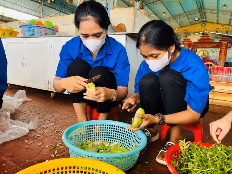 Các tình nguyện viên của Đoàn Thanh niên Thị trấn Chư Ty (huyện Đức Cơ) nấu ăn miễn phí cho các sĩ tử. (Ảnh Phan Lài) 