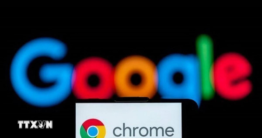 Biểu tượng Chrome trên màn hình điện thoại và biểu tượng Google (phía sau). (Ảnh: Getty Images/TTXVN)