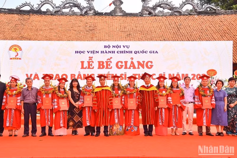 Thứ trưởng Nội vụ Triệu Văn Cường, Giám đốc Học viện Hành chính Quốc gia Nguyễn Bá Chiến và các đại biểu chụp ảnh lưu niệm cùng các tân Tiến sĩ. (Ảnh: NHẬT QUANG)
