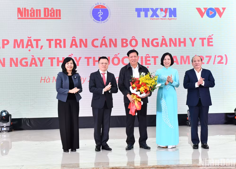 Tổng Biên tập Báo Nhân Dân Lê Quốc Minh và lãnh đạo các cơ quan báo chí chủ lực tặng hoa cho Thứ trưởng Thường trực Bộ Y tế Đỗ Xuân Tuyên nhân Ngày Thầy thuốc Việt Nam. (Ảnh: ĐĂNG KHOA)