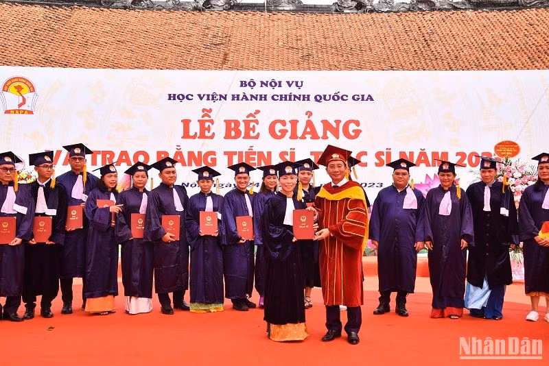 Giám đốc Học viện Hành chính Quốc gia Nguyễn Bá Chiến trao bằng cho các tân Thạc sĩ. (Ảnh: NHẬT QUANG)