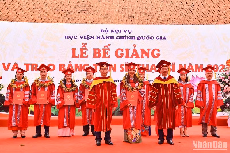 Thứ trưởng Nội vụ, PGS, TS Triệu Văn Cường và Giám đốc Học viện Hành chính Quốc gia, PGS, TS Nguyễn Bá Chiến trao bằng Tiến sĩ cho các nghiên cứu sinh đã hoàn thành đề án năm 2023. (Ảnh: NHẬT QUANG)