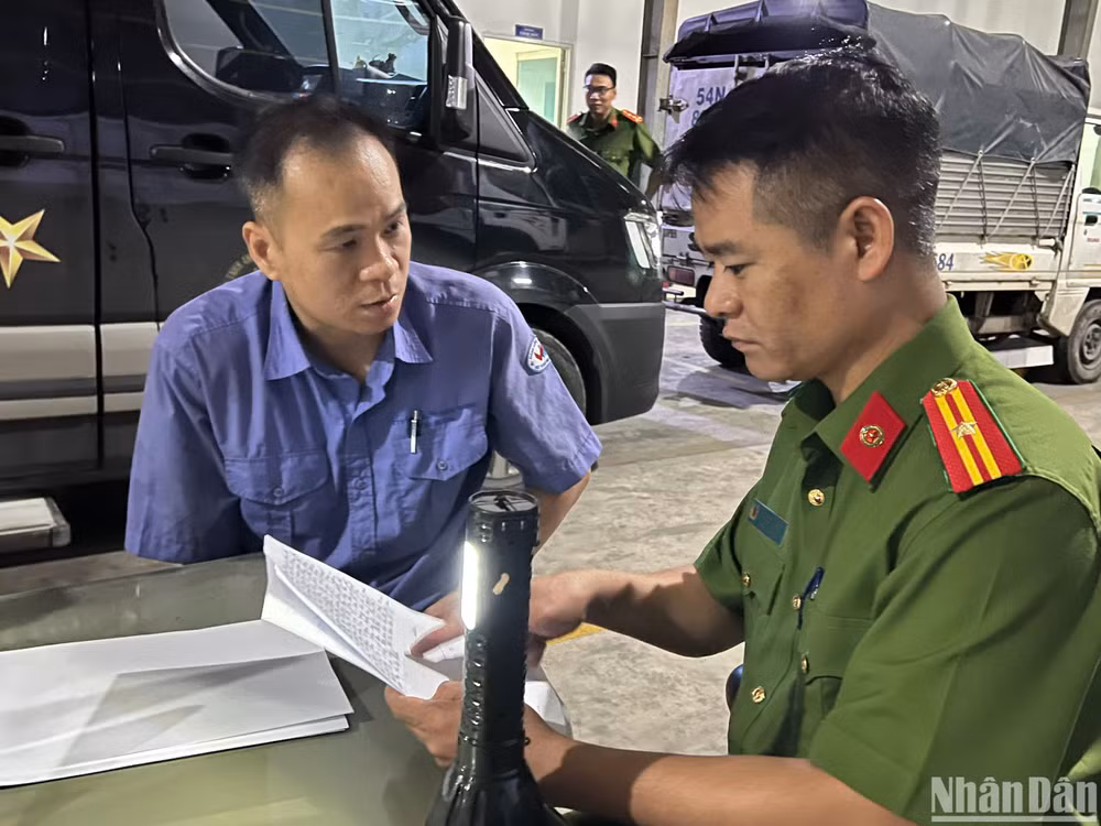 Điều tra viên lấy lời khai một nhân viên đăng kiểm.