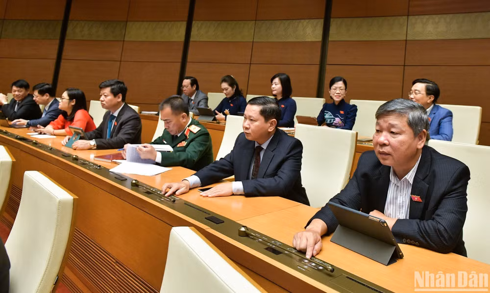 Các đại biểu Quốc hội biểu quyết thông qua dự thảo Luật Các tổ chức tín dụng (sửa đổi). (Ảnh: DUY LINH)