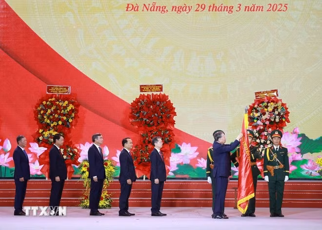 Tổng Bí thư Tô Lâm gắn Huân chương Lao động hạng Nhất lên Cờ truyền thống của Thành phố Đà Nẵng. (Ảnh: TTXVN)