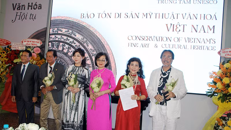 Ông Phạm Hoàng Thịnh (bìa trái), Trưởng Văn phòng đại diện Liên Hiệp các Hội UNESCO Việt Nam tại Thành phố Hồ Chí Minh trao quyết định và chúc mừng Ban Giám đốc Trung tâm.