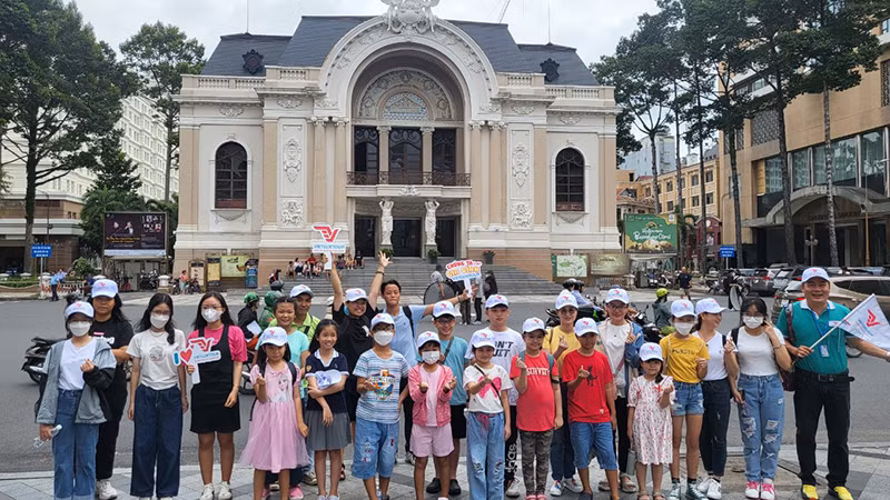 Các em thiếu nhi chụp ảnh lưu niệm trước Nhà hát Thành phố.