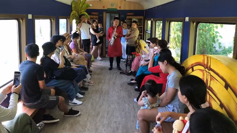 Biểu diễn văn nghệ phục vụ hành khách trên toa cộng đồng.