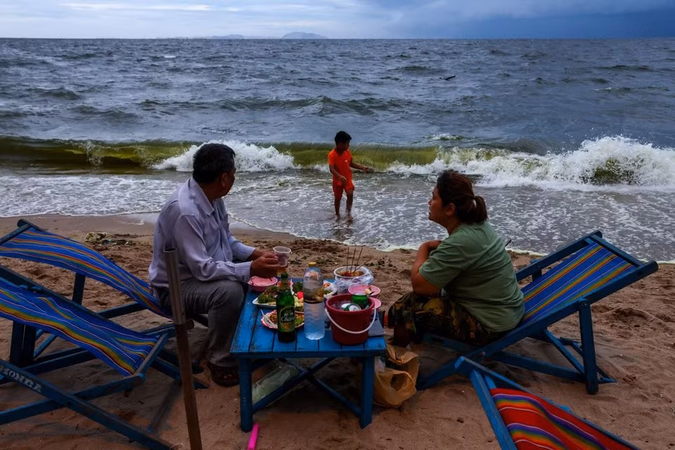 Khách du lịch ăn tối bên bãi biển có nước màu xanh lục ở Bang Saen ở tỉnh Chonburi, Thái Lan. Ảnh: Reuters.