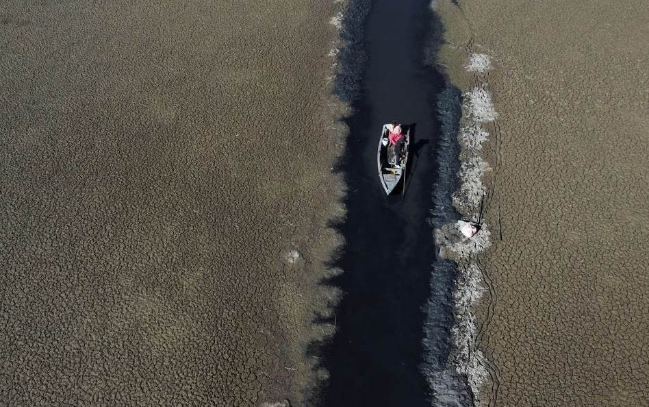 Thuyền đi qua một con nước hẹp ở hồ Titicaca, Bolivia, ngày 3/8. Ảnh: Reuters.