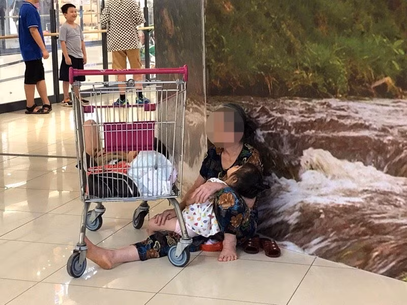 Bà trông cho các cháu có giấc ngủ trưa trong trung tâm thương mại.