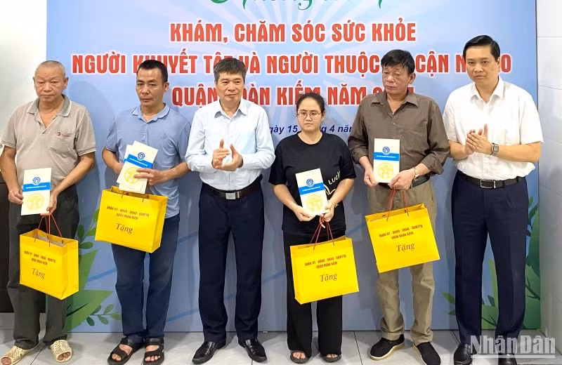 Quận Hoàn Kiếm trao quà và tặng sổ Bảo hiểm xã hội cho người dân thuộc hộ cận nghèo.