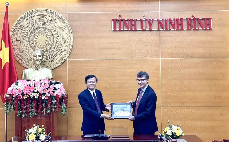 Đồng chí Đoàn Minh Huấn, Ủy viên Trung ương Đảng, Bí thư Tỉnh ủy Ninh Bình tặng quà lưu niệm cho ông Jonathan Baker, Trưởng Văn phòng đại diện của UNESCO tại Việt Nam. (Ảnh: YẾN TRINH)