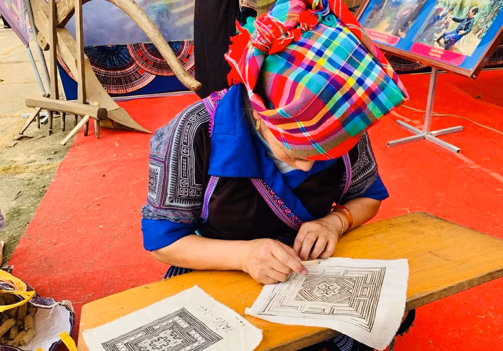 Phụ nữ H'Mông Mù Cang Chải vẽ sáp ong trên vải. (Ảnh THANH SƠN)