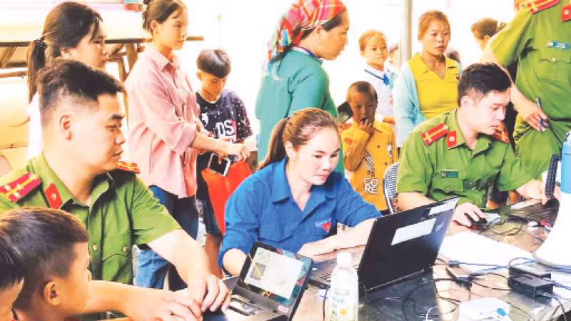 Đoàn viên, thanh niên hỗ trợ đăng ký trên Cổng dịch vụ công trực tuyến của Bộ Công an. (Ảnh Vân Thảo) 